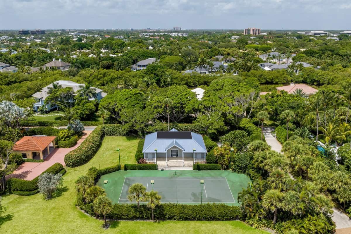 The tennis court is accompanied by a guest house that has a deep front porch. Image courtesy of Toptenrealestatedeals.com.