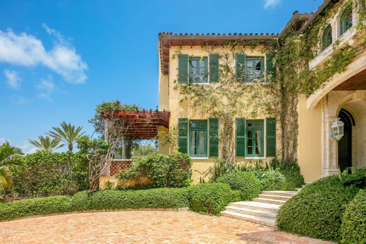 Creeping ivy and green shuttered windows complement well with the yellow exterior walls. Image courtesy of Toptenrealestatedeals.com.