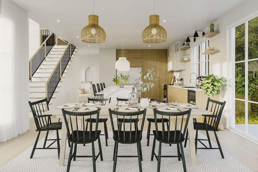 Dining area with a pair of wicker pendants and wooden dining set sitting on a chevron area rug.