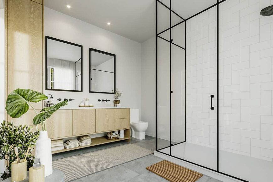 The primary bathroom includes a toilet and a wooden vanity equipped with two sinks, a marble countertop, and a pair of framed mirrors.