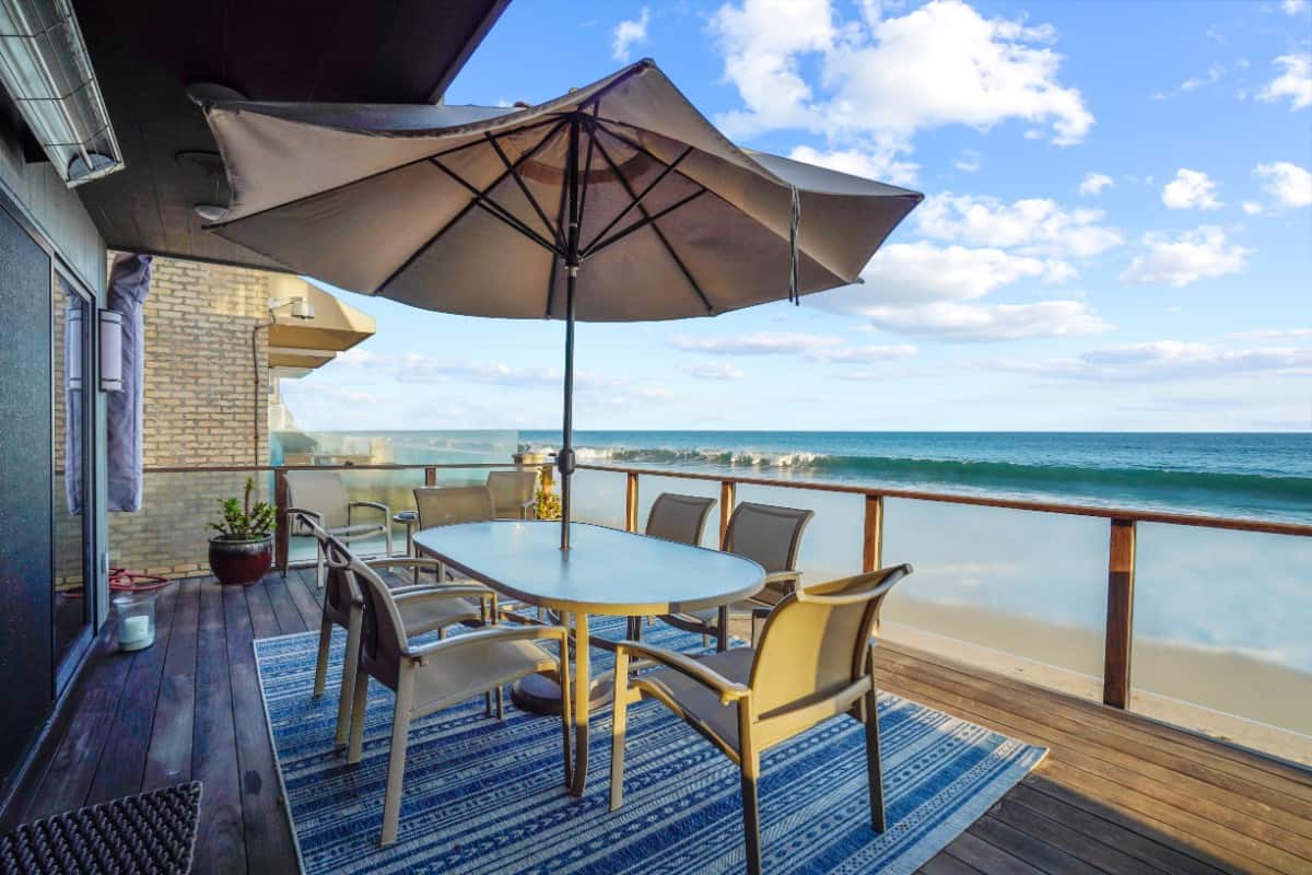 One of the decks has an outdoor dining set with an umbrella for shaded alfresco dining. Image courtesy of Toptenrealestatedeals.com.