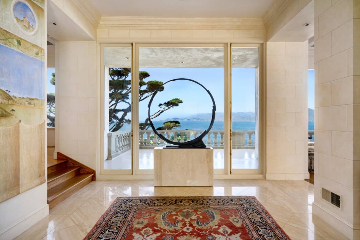 The foyer has a contemporary decor and floor-to-ceiling windows that look out the balcony. Image courtesy of Toptenrealestatedeals.com.