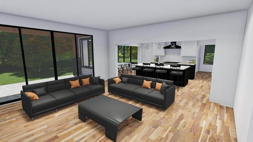 A spacious living room with black leather sectionals, a matching coffee table, and sliding glass doors that open to the rear deck.