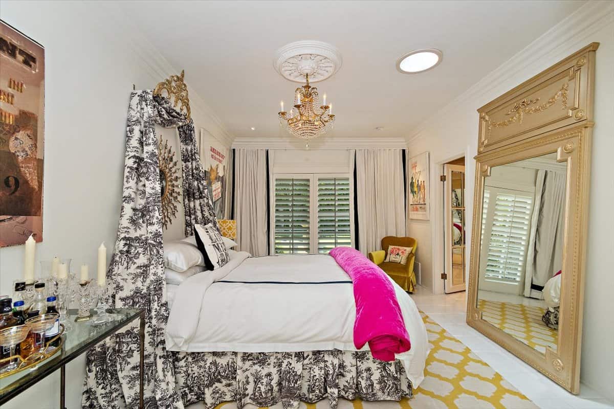 This bedroom has a comfy bed, a massive mirror, and louvered windows that look out at the pool. Image courtesy of Toptenrealestatedeals.com.