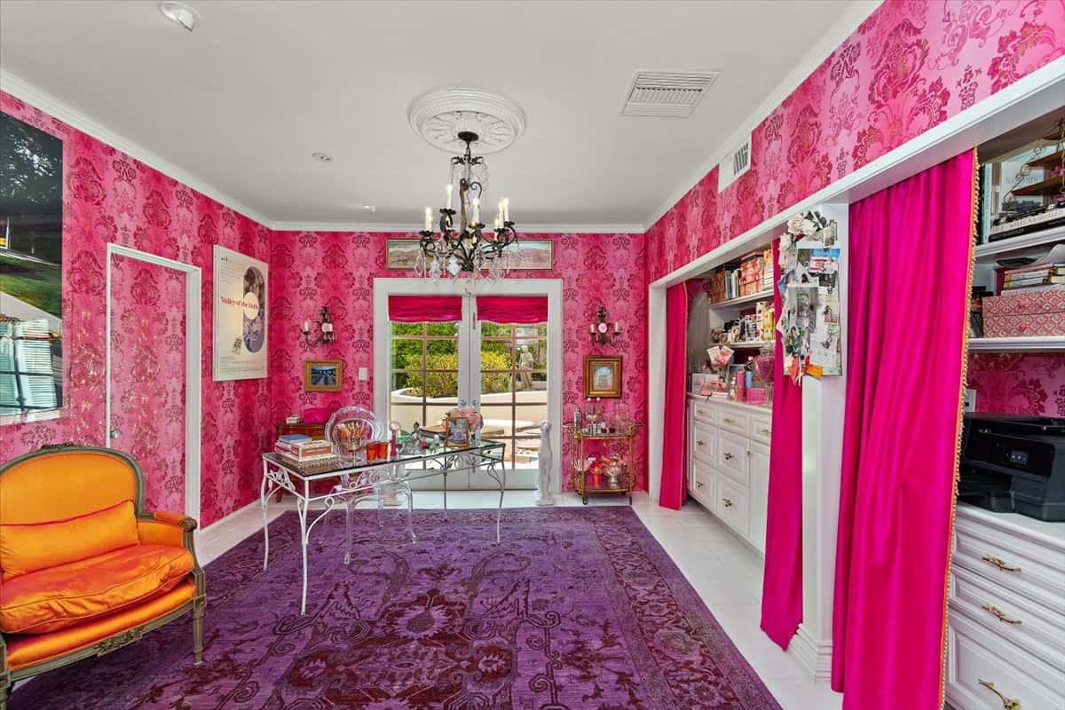 The study is decorated with bold pink wallpaper and a pretty purple rug. Image courtesy of Toptenrealestatedeals.com.