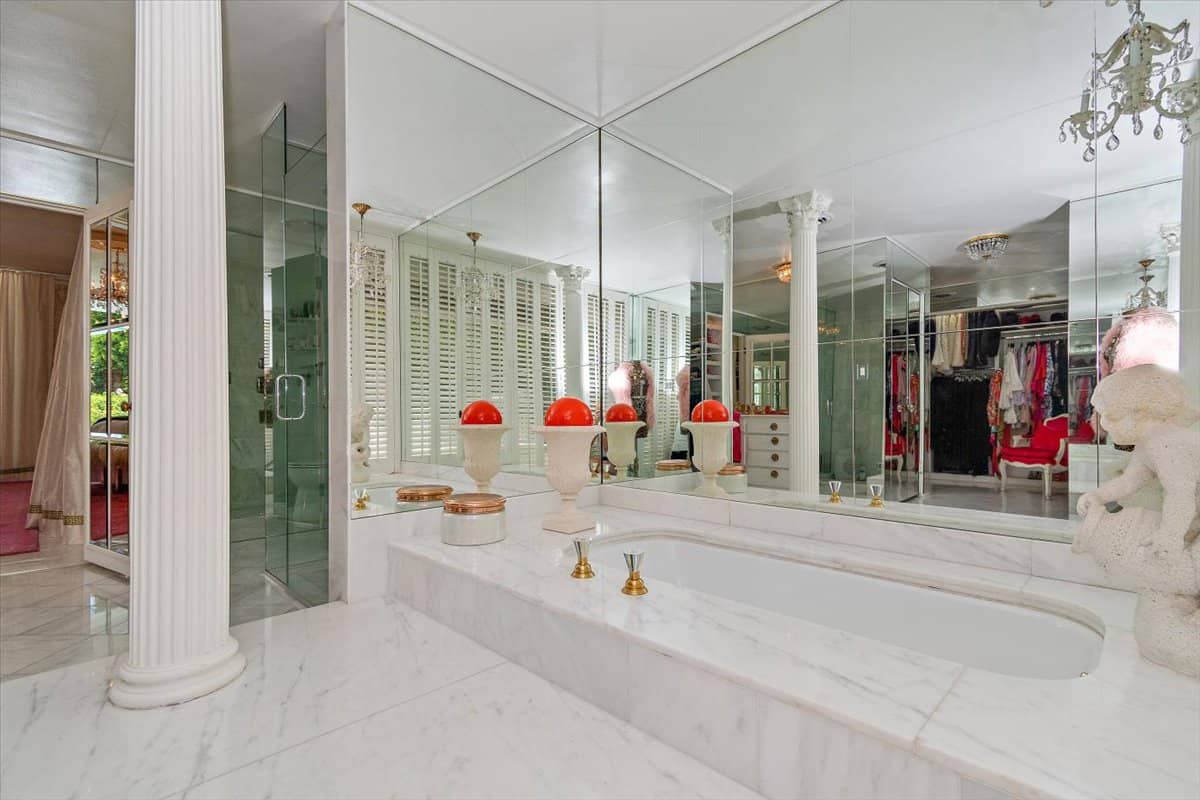 The primary bathroom also speaks opulence showcasing a deep soaking tub surrounded by mirrors. Image courtesy of Toptenrealestatedeals.com.