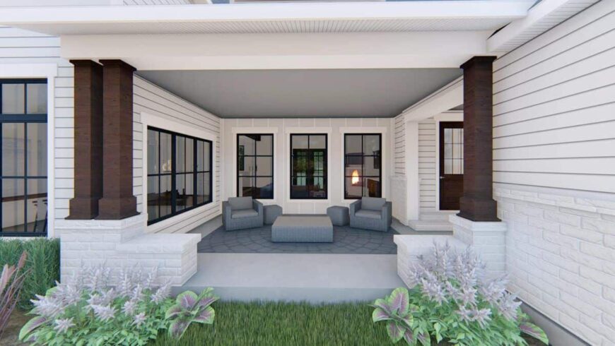 The covered porch is filled with gray seats and a matching coffee table over flagstone flooring.