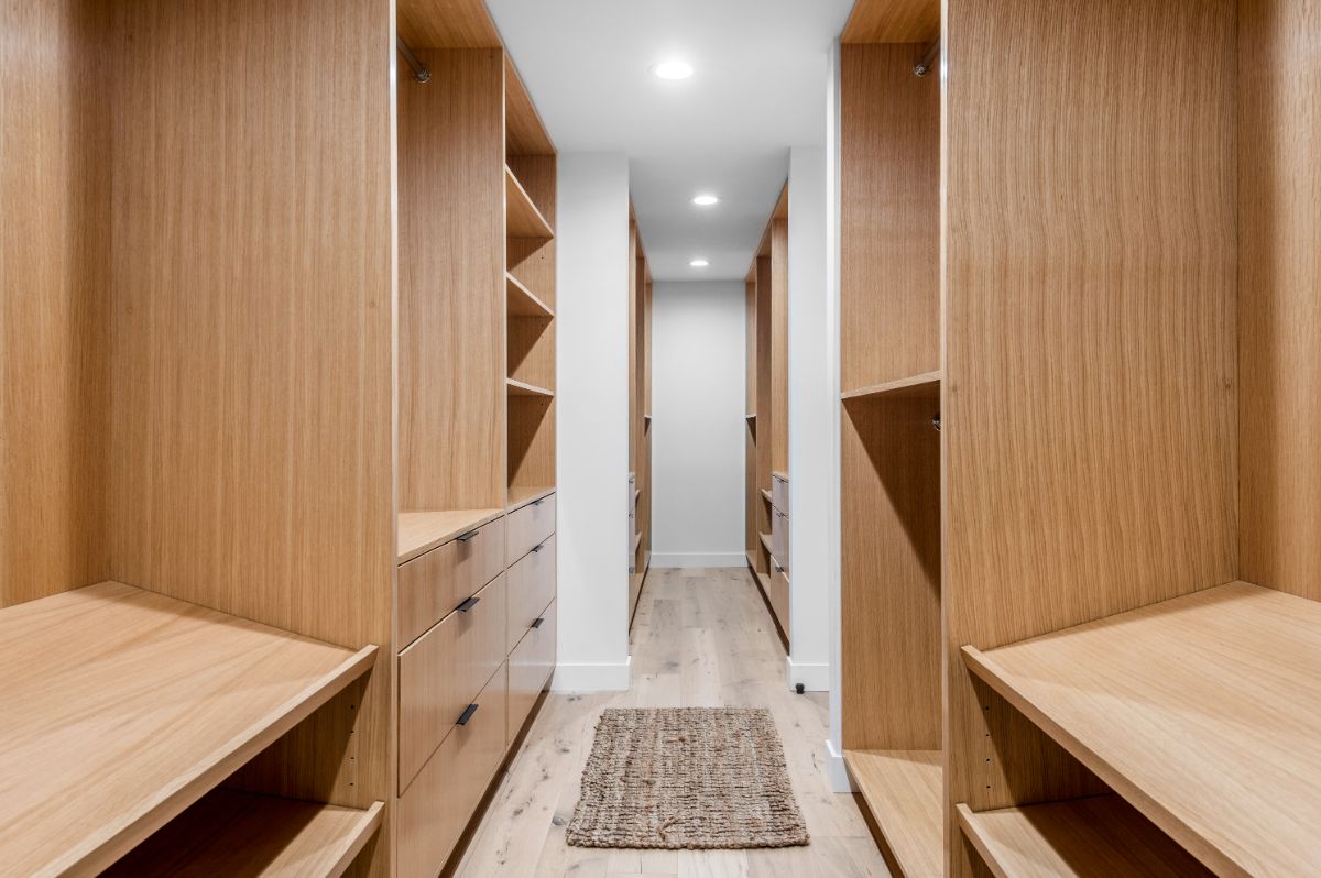 The walk-in closet, complete with wooden cabinets and shelves. Image courtesy of Toptenrealestatedeals.com