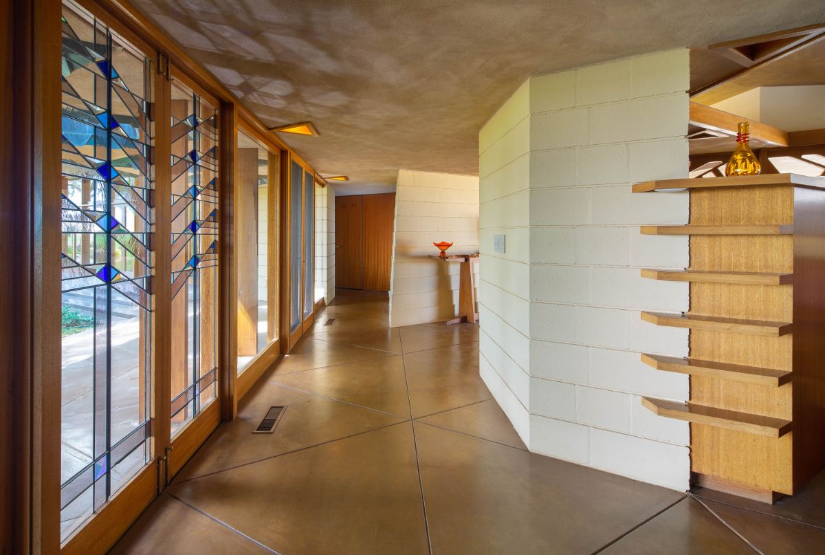 The main entrance features glass walls with hardwood frames. Image courtesy of Toptenrealestatedeals.com