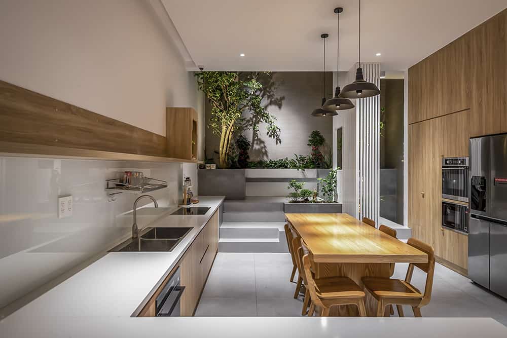 The kitchen has L-shaped counters and floor-to-ceiling cabinets surrounding the dining area.