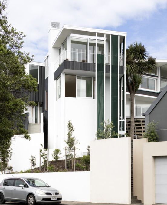 An exterior photograph of the northern elevation from Salmont Place features jade-green vertical mesh screens, with the surrounding foliage, captured from an external vantage point.