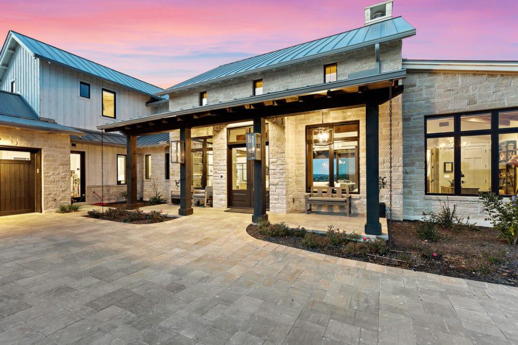 The entry porch is graced with black wood beams and exposed rafter tails.