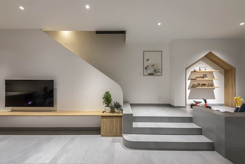 Warm lights and wood shelves soften the modernity in the living room.