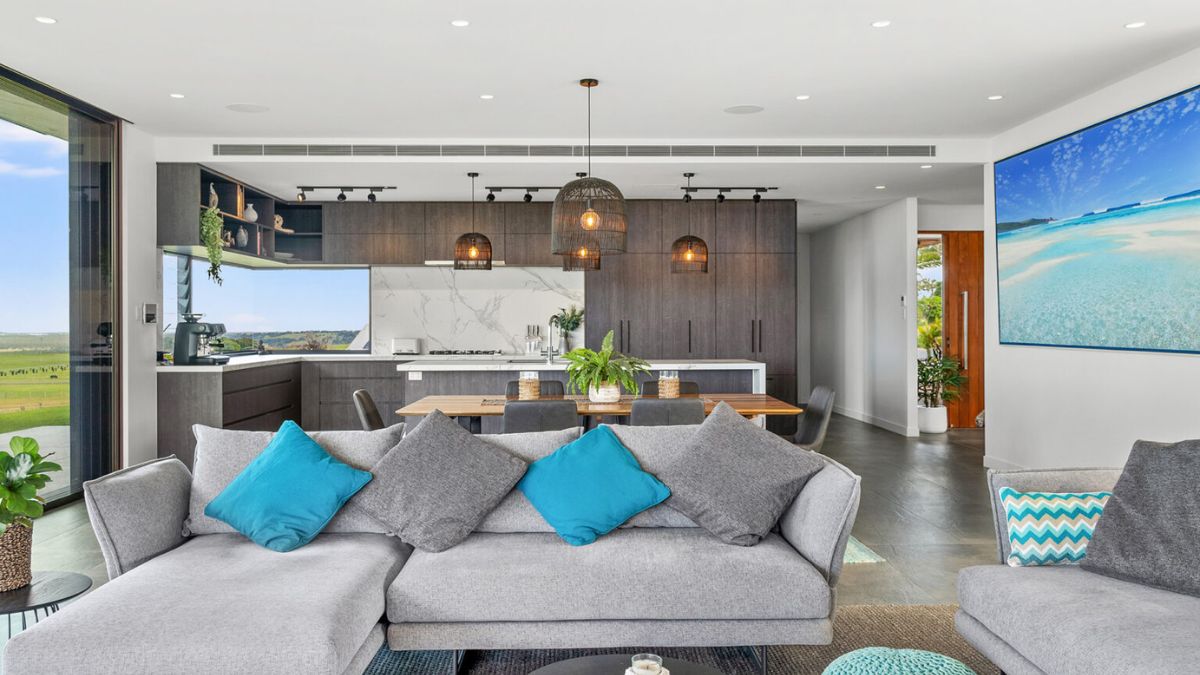 This property features an open-concept shared living space, comprising of a kitchen, living room, and dining area, all seamlessly connected and easily accessible with just a few steps between each.