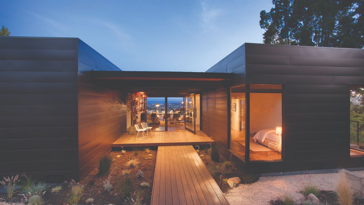 The rear of the house boasts a beautiful patio area, featuring a unique and elegant flooring made from walnut. 