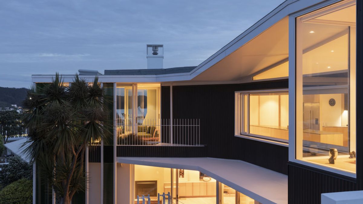 A close-up photograph of the exterior of the second floor of Salmont Place, highlighting the combination of concrete and glass in the wall construction, captured during the beautiful sunset lighting.