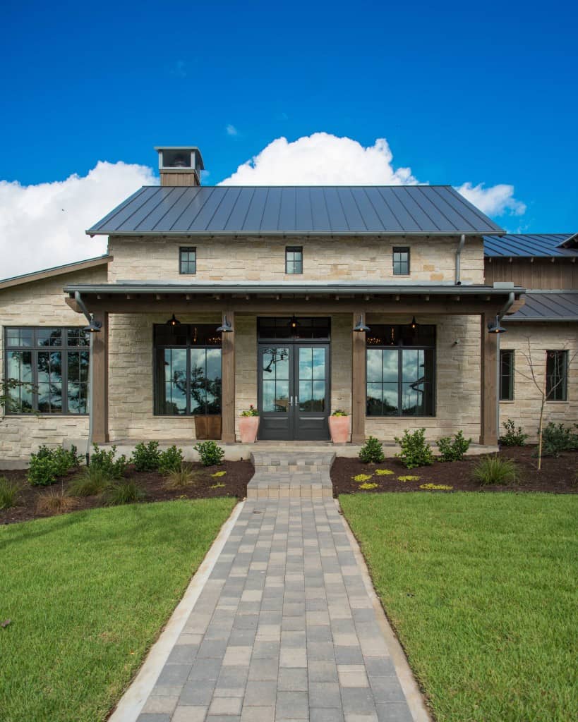 A brick walkway leads to the covered front porch with a french entry door.