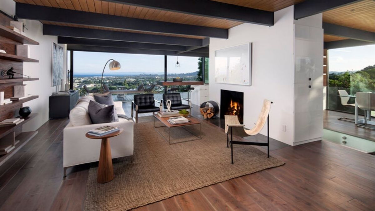 The interior of the living room offers a detailed view of the comfortable and inviting atmosphere created by the tasteful selection of furniture, a fireplace, and exposed wooden beams. 