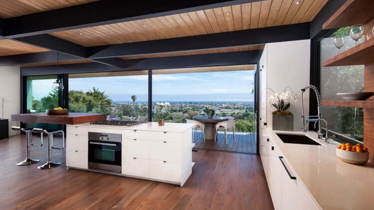 The kitchen area offers a detailed view of its design and features, including the ability to take in the picturesque views from the high elevation through the use of wide glass windows