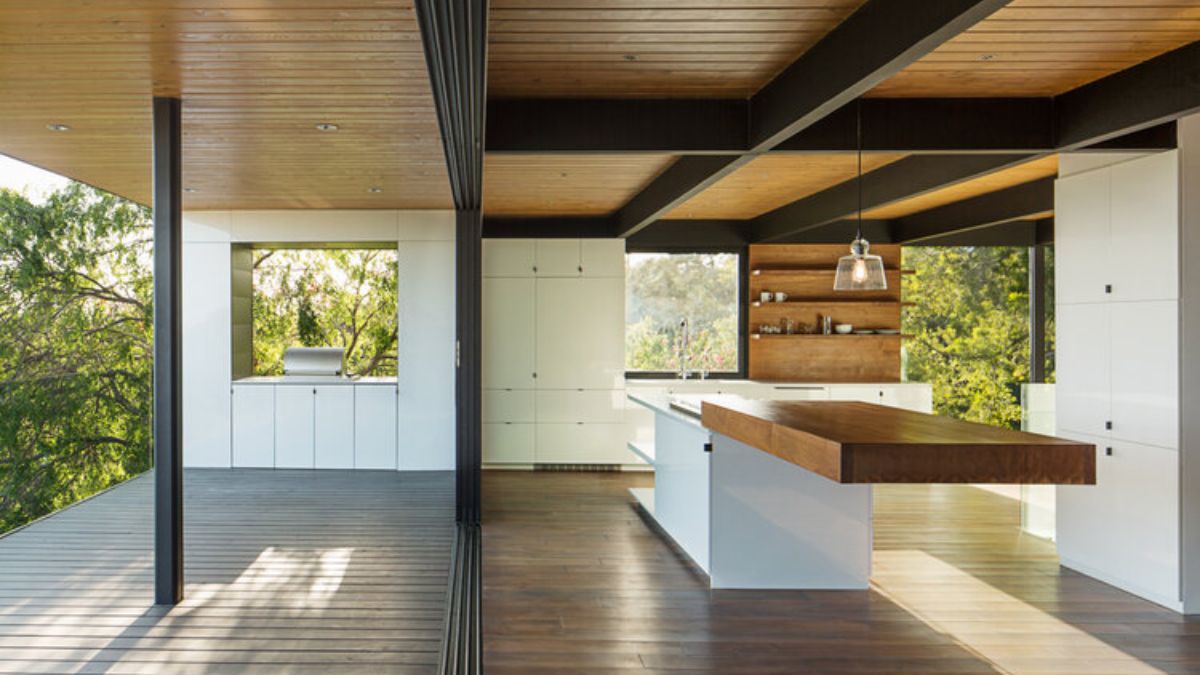 The interior of the dining room showcases a unique and striking design element in the form of a center island that features a long, wooden extension.