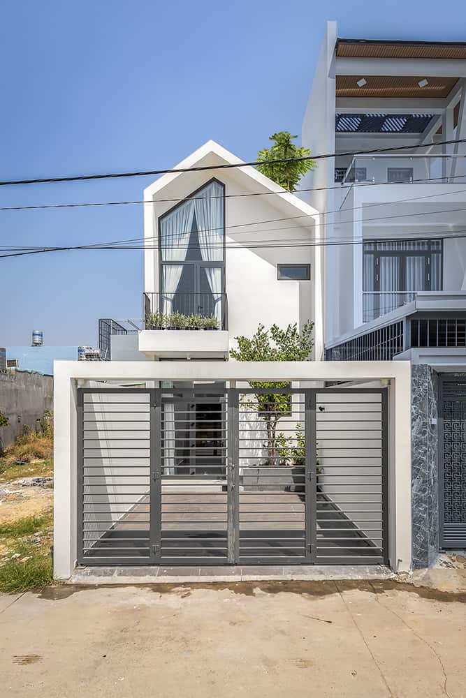 Home facade with an asymmetrical gable, modern windows, and a sleek entrance with a steel gate.