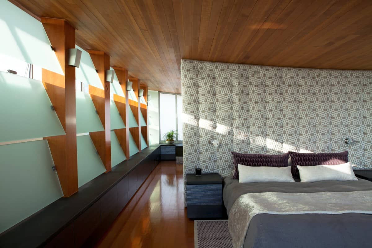 A bespoke headboard doubles as a divider between the bedroom and its ensuite.