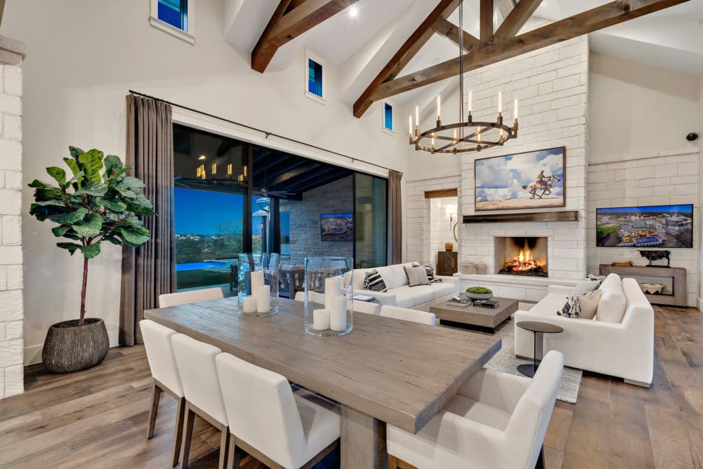 The dining area has a rustic wooden table surrounded by beige upholstered chairs.