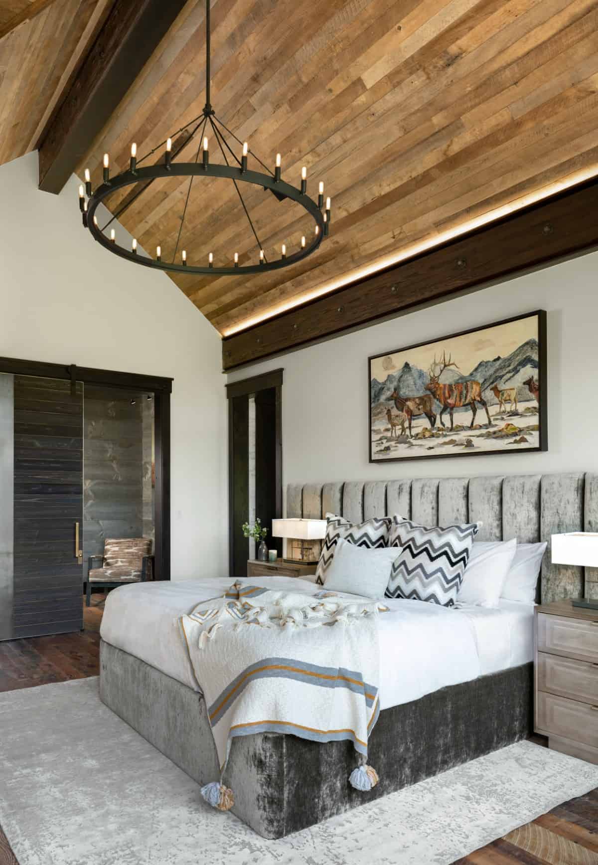 This bedroom has a cathedral ceiling and velvet bed crowned with a bespoke headboard.