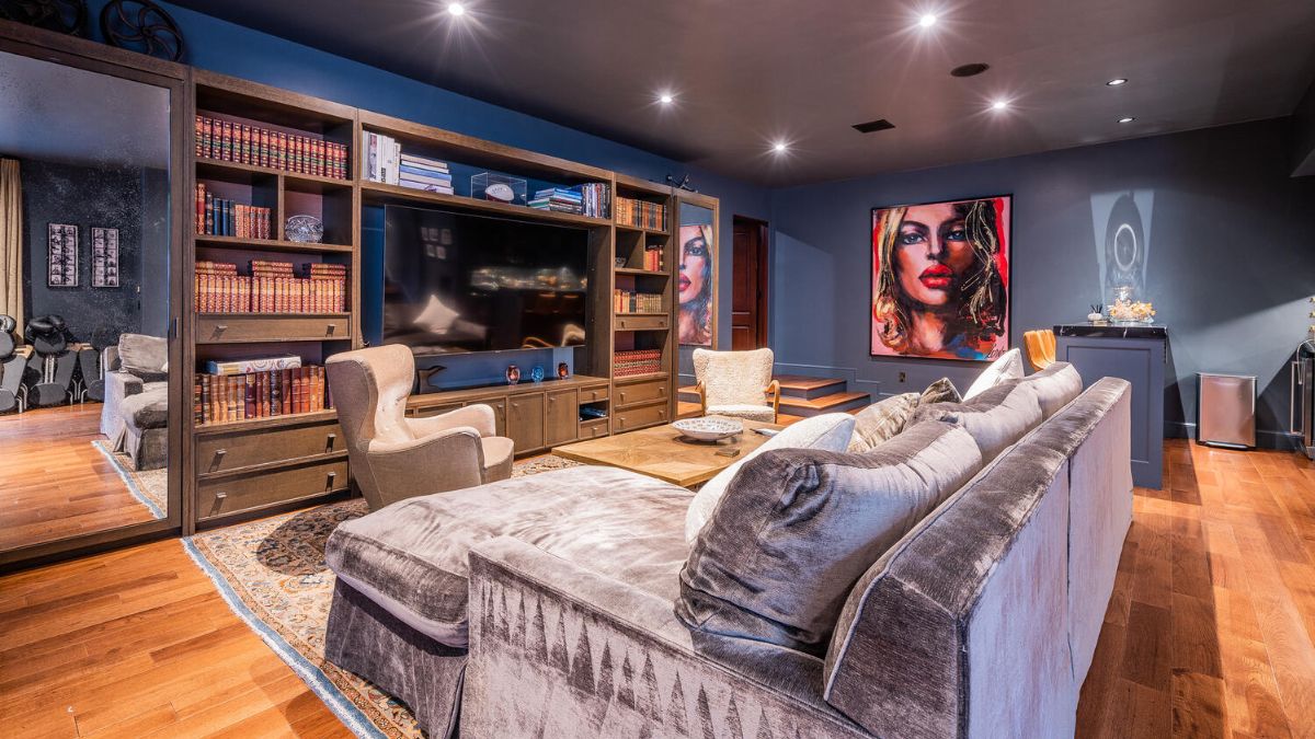 This area also exudes a different vibe than the other rooms because it has a cabinet arrangement with the TV in the middle and book shelves and a full-length mirror on either side.