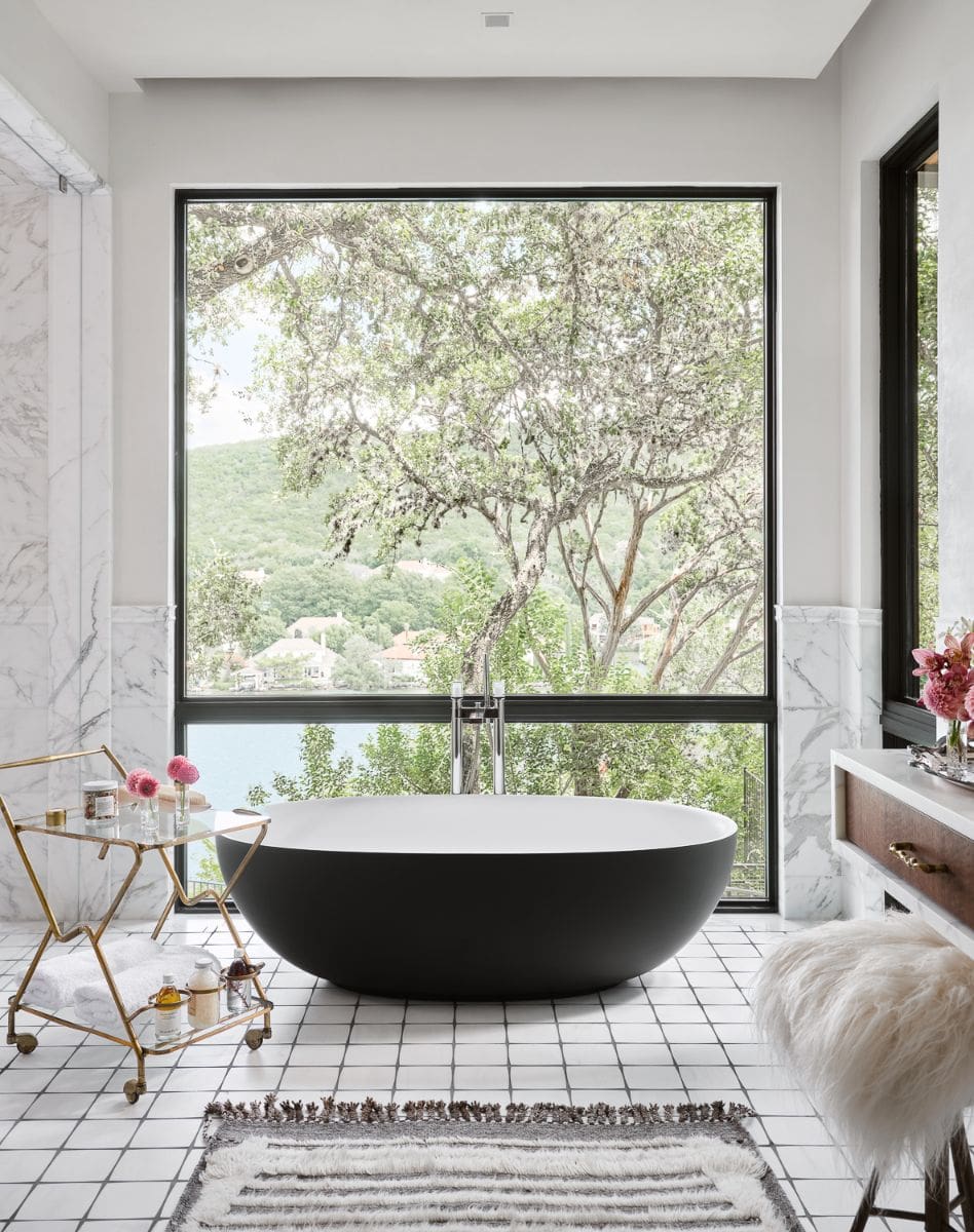 The main bathroom, with a freestanding tub and stunning views of the lake and the surrounding heritage oak trees.