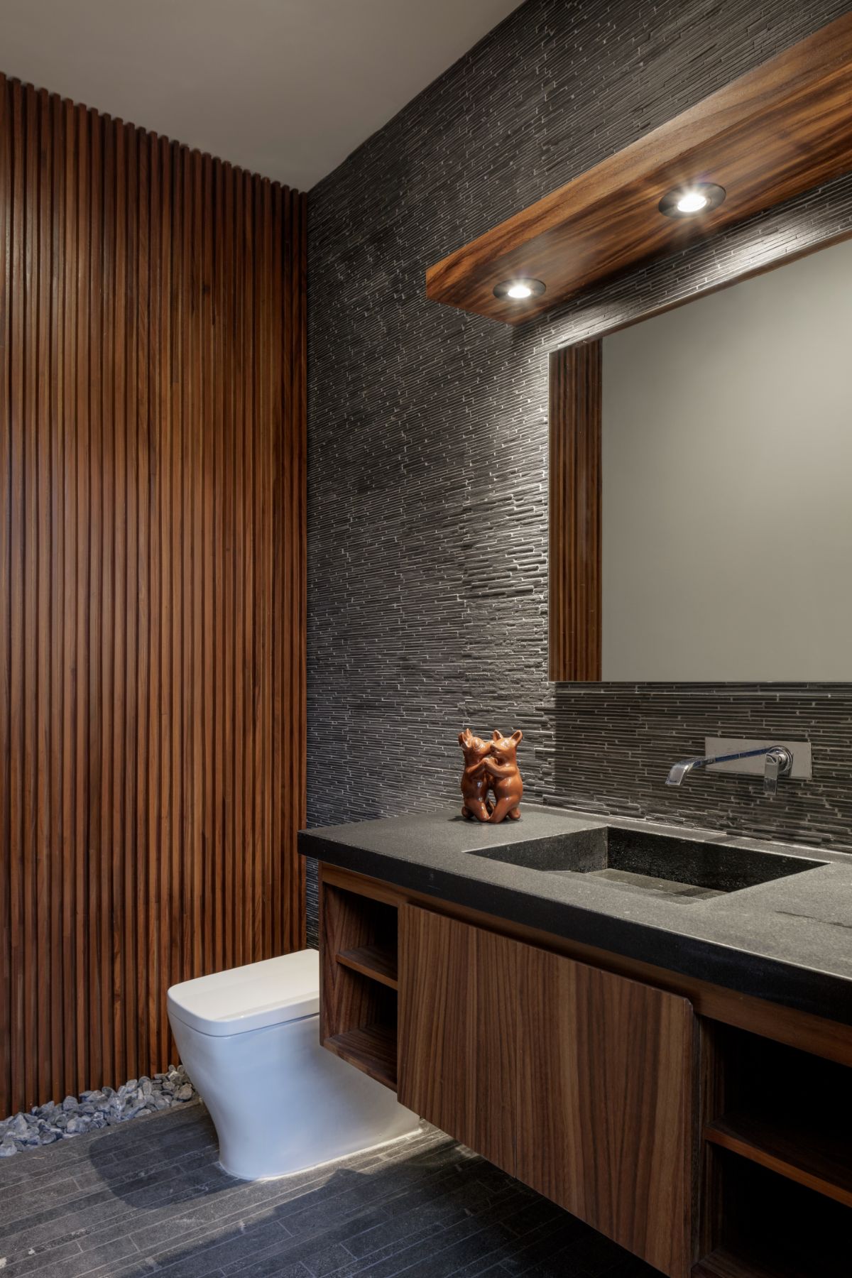 The bathroom features a floating vanity, and volcanic rocks were used as decoration.