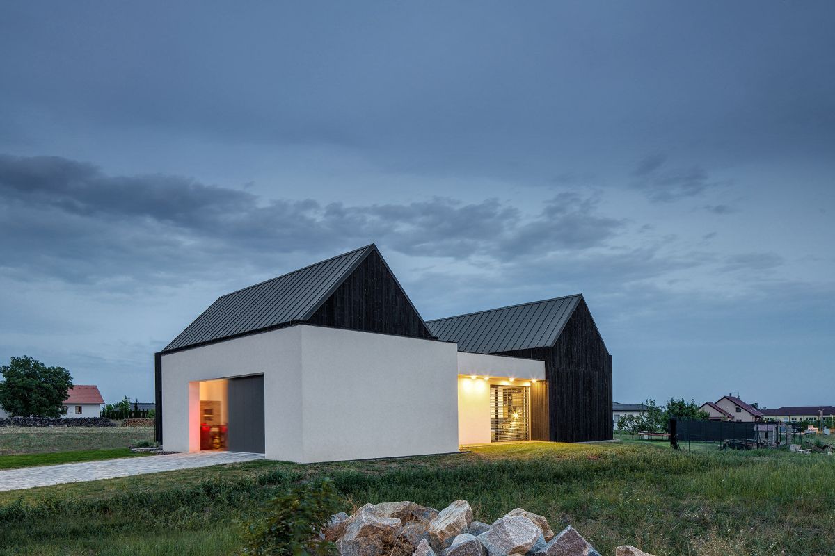 The back facade of a contemporary two-tower house in a small village.