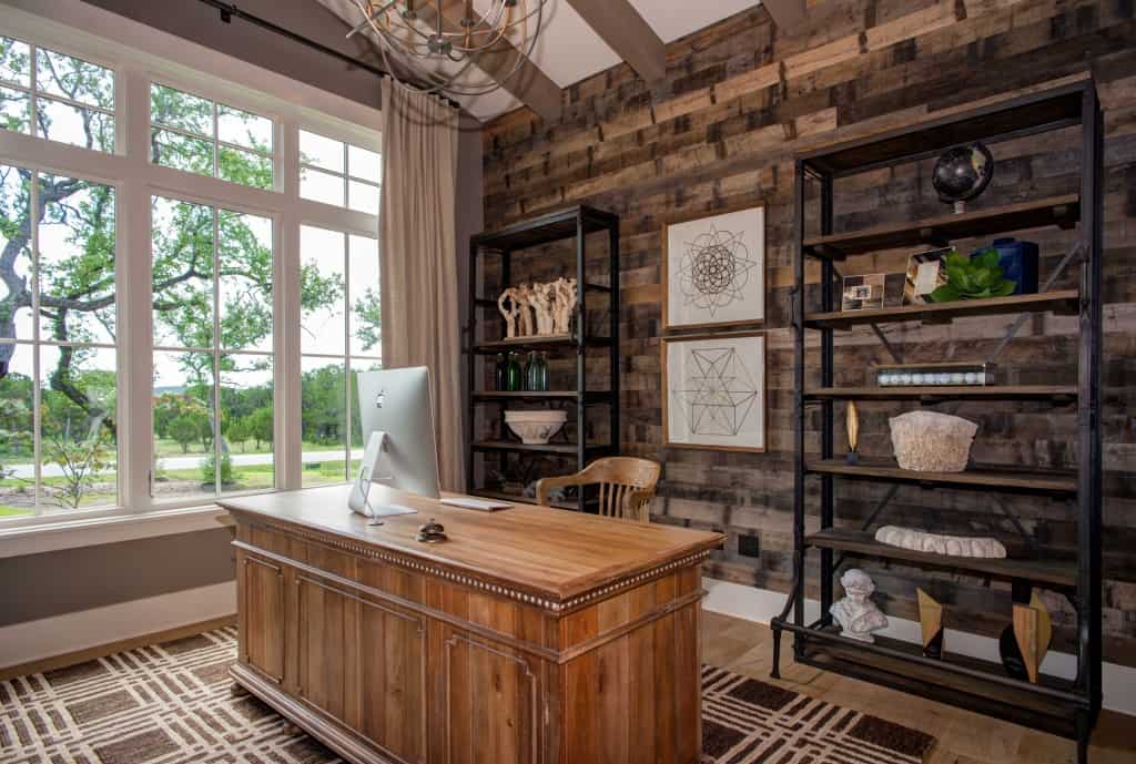 A wood-paneled accent wall graced with framed artworks sets a nice backdrop to the home office.