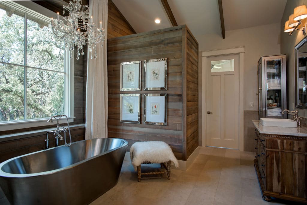 Wood panels and cabinets enhance the cozy ambiance in the primary bathroom.