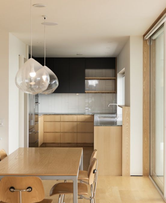 A close up shot of the downstair's dining area leading to the kitchen, showcasing its minimalist interior design.