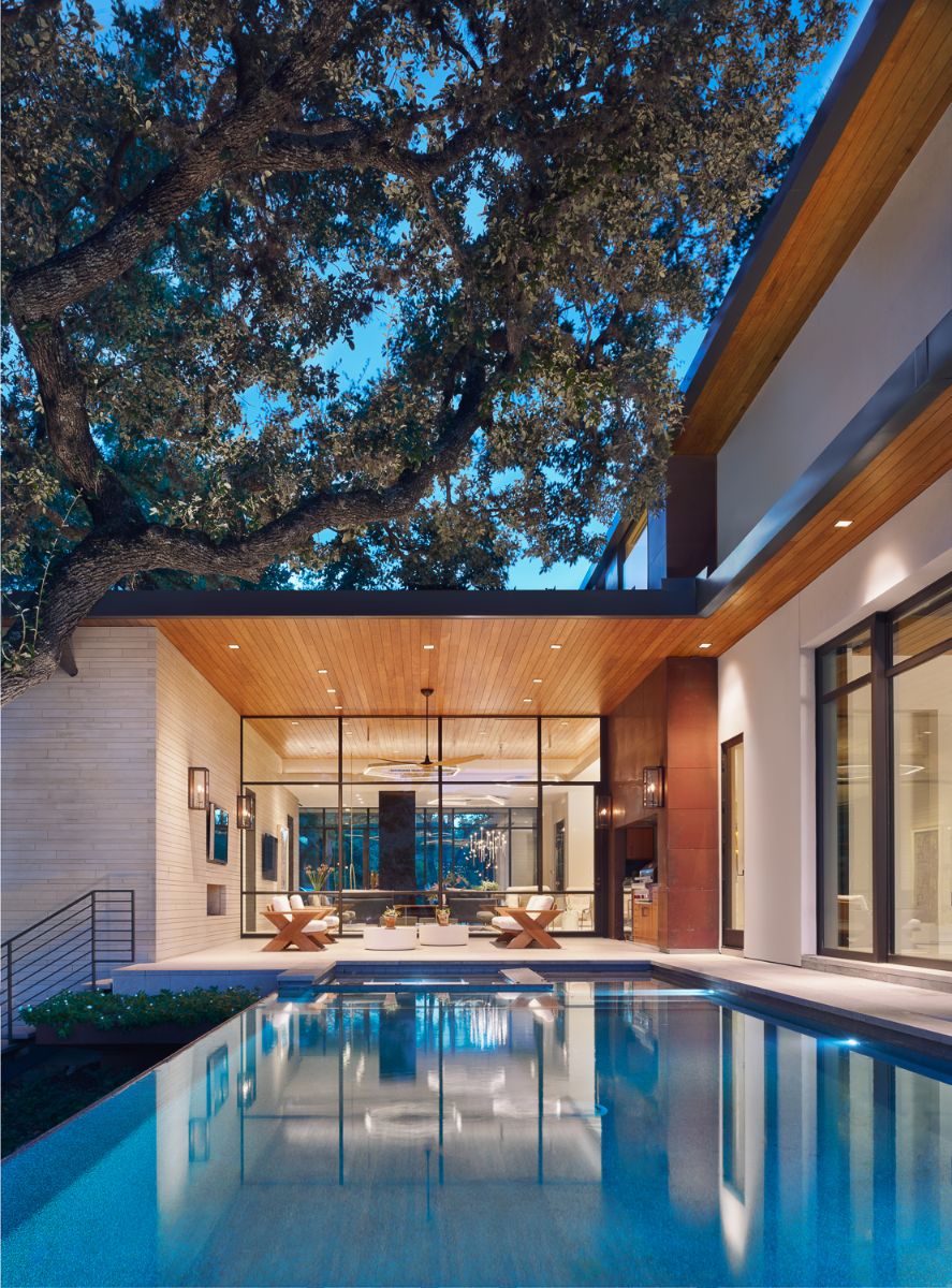 The pool has a two-sided negative edge and is surrounded by heritage oak trees.