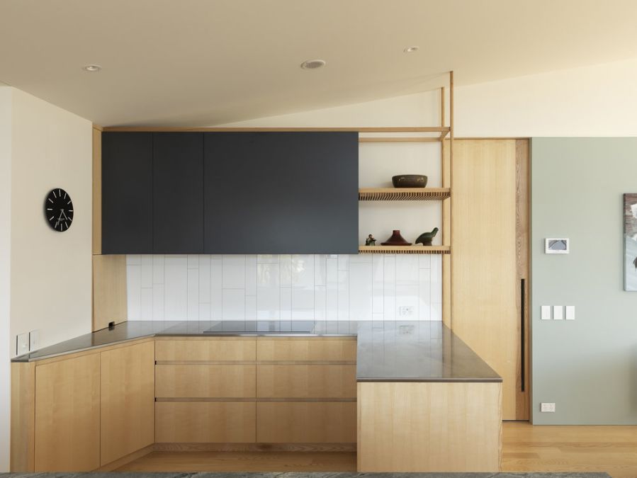 A focus shot of a timeless palette of pale American ash cabinetry in the kitchen area.