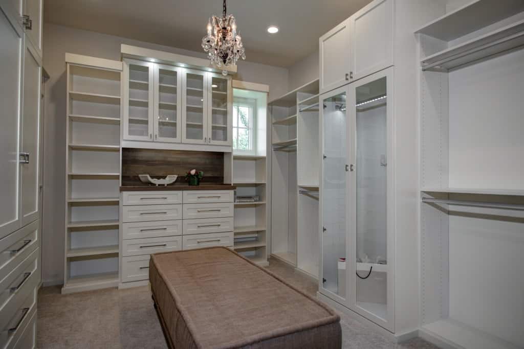 The primary walk-in closet offers ample storage and a comfy seat in the middle.