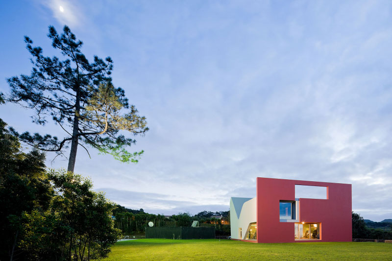 The view of the house at night showcases its distinct color.