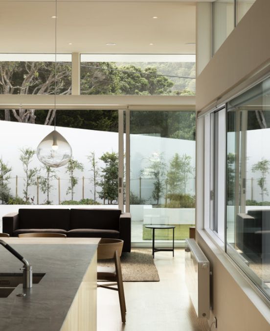 An interior shot of living area leads to an outside terrace and lawn area.