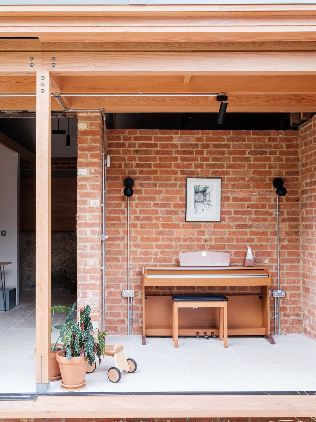 The piano is placed in a small area with brick walls.