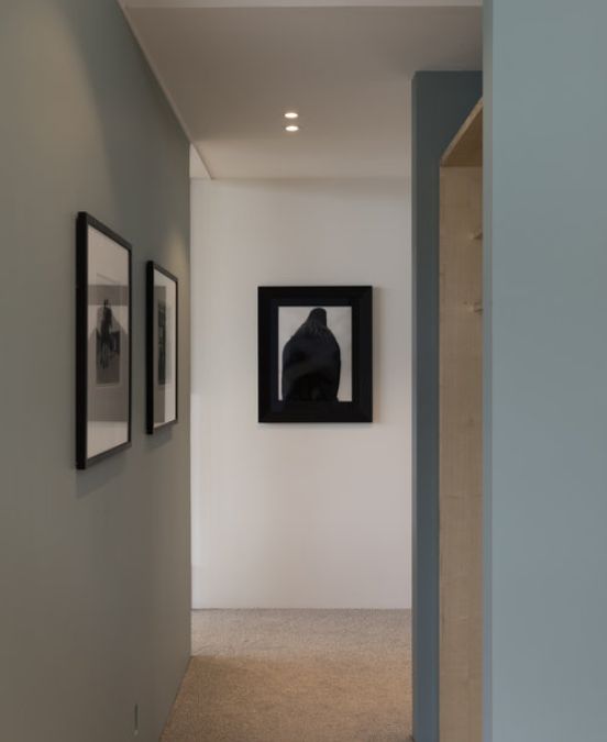 An interior shot of a hallway, highlighting the artwork frames hanging on the wall.