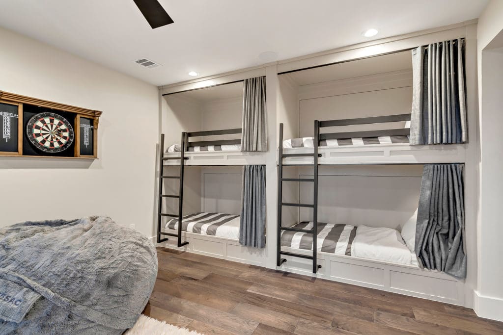 This bedroom features custom bunk beds with wrought iron ladders and railings.