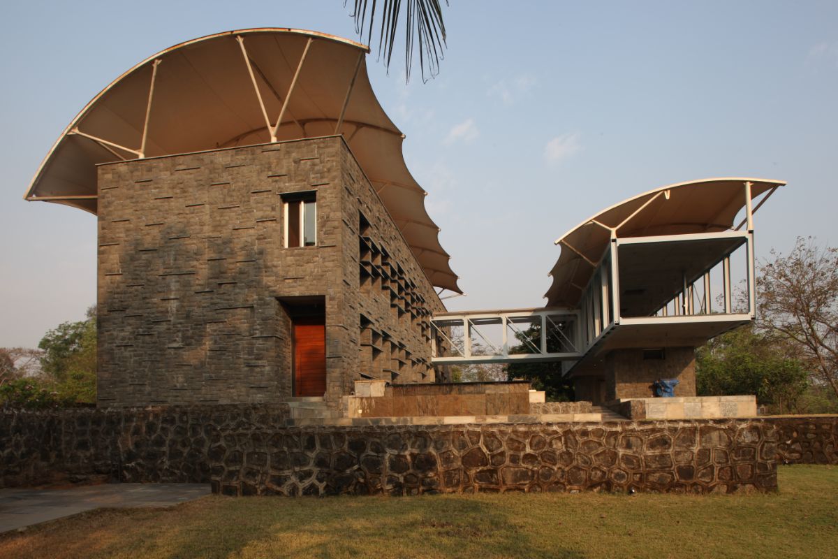 The exterior of the house is made of native basalt stone. A bridge connects the main building with the veranda.