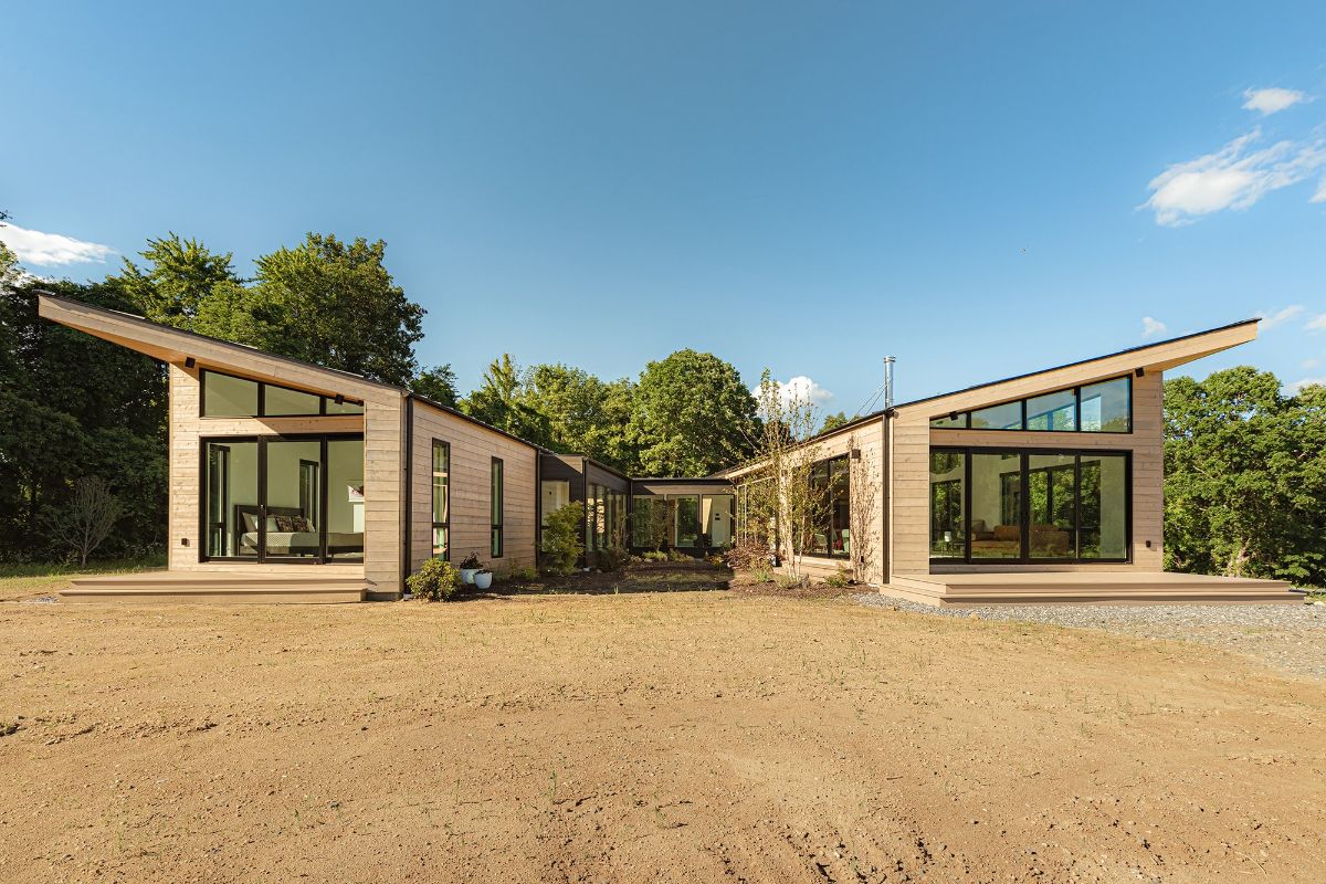 The house has stained cedar siding used for exterior and the wing-shaped structure makes the house unique.