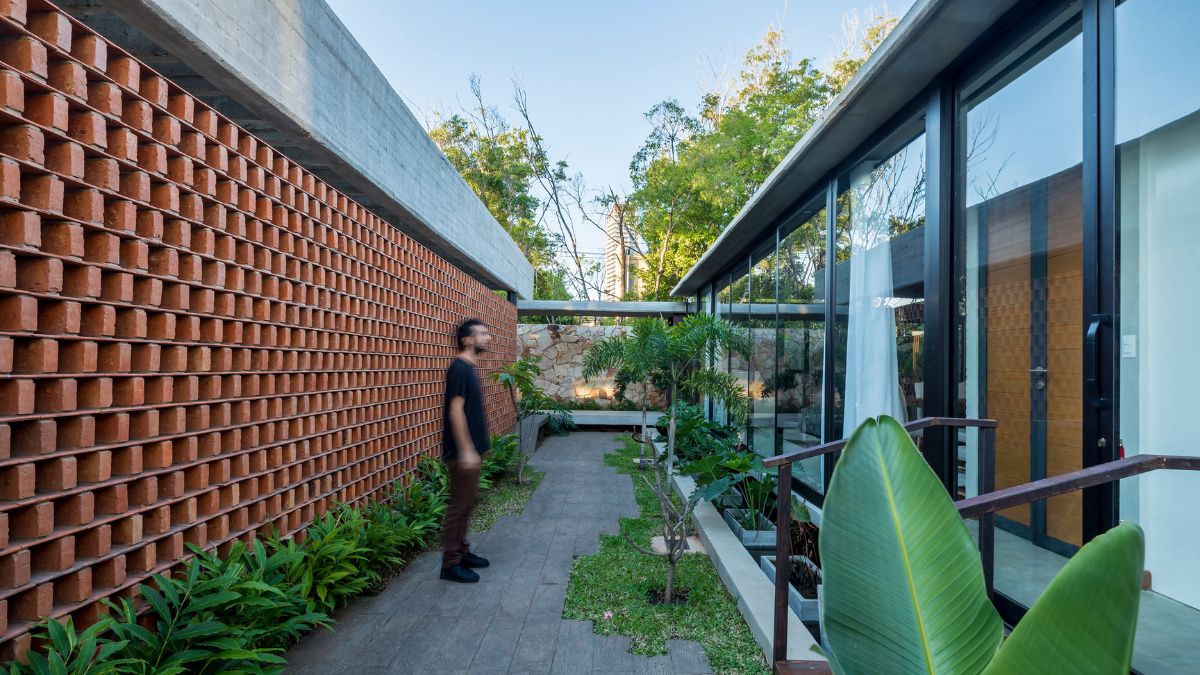 The big wall glasses that secure the house interior from the outside can be viewed on the other side of the brick walls when you entrance the property.