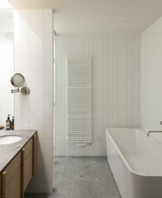 An interior shot of the bathroom that has a tiling laid out in an irregular pattern, hinting at the verticality of the exterior.