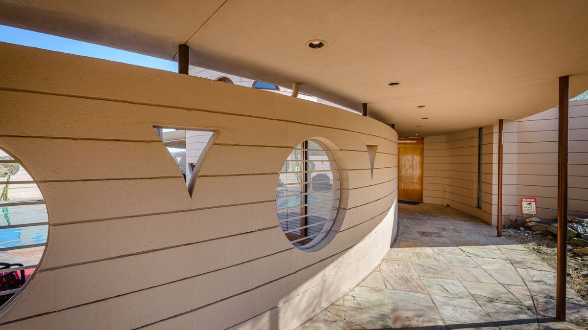 This is a closer look at the entrance, which has a large circular window that overlooks the house's pool.