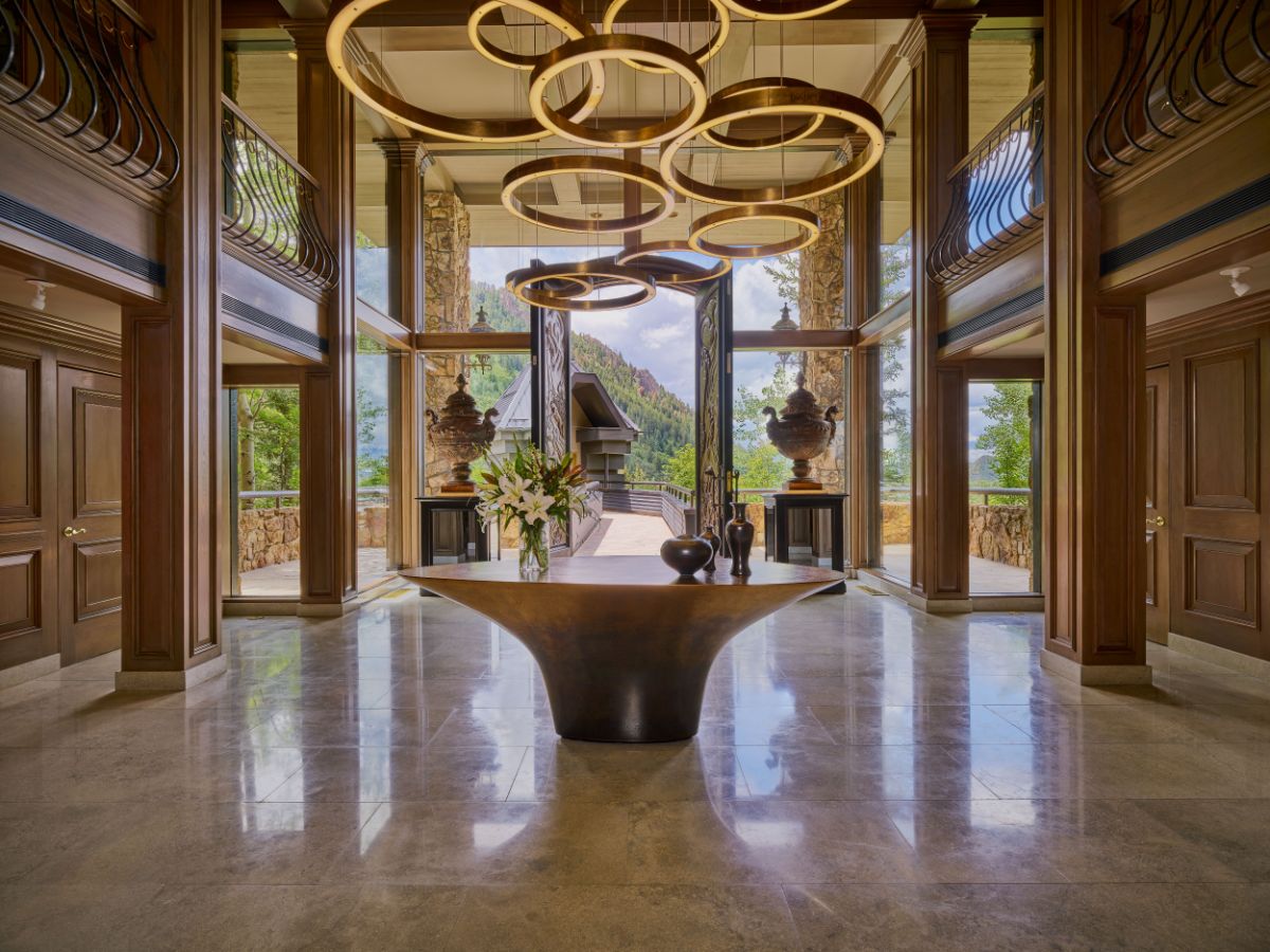 The light-filled two-story foyer with gold accents and unobstructed views of the Aspen Mountain Gondola. Image courtesy of Toptenrealestatedeals.com