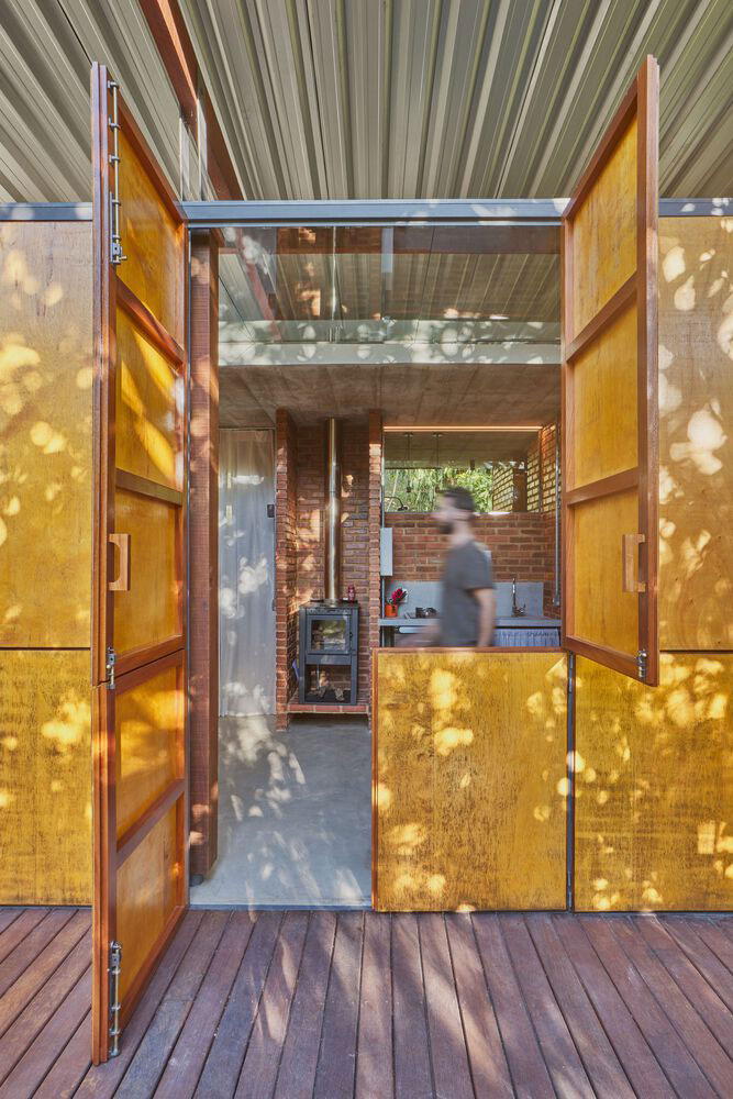 The wooden deck and the plywood panel open at two different heights gives the house a unique look.